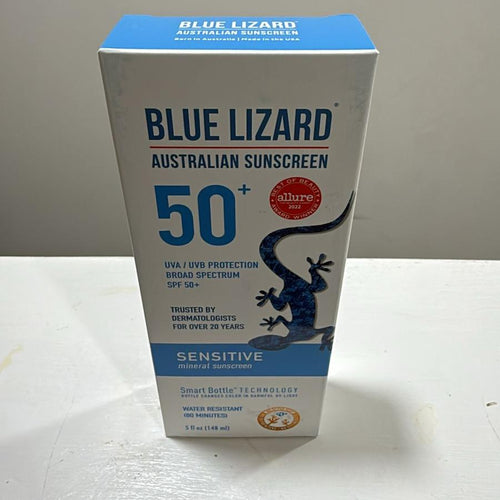 Blue Lizard Australian Sunscreen SPF 50+ Sensitive sunscreen box, 150ml, standing on a white surface against a plain light gray wall.